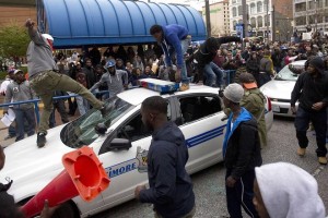 Protesters in Baltimore damage a police car