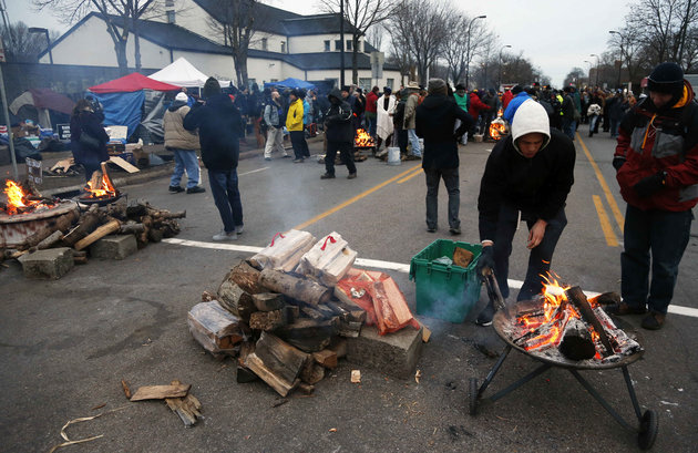 Fire pits sit in the street outside the Black Lives Matter encampment to keep protesters warm before a candlelight vigil, Friday, Nov. 20, 2015, in front of the Minneapolis Police Department's Fourth Precinct in Minneapolis. The fatal shooting of Jamar Clark, a black man, by a Minneapolis police officer, has pushed racial tensions in the city's small but concentrated minority community to the fore, with the police precinct besieged by the makeshift encampment and many protesters. (AP Photo/Jim Mone)